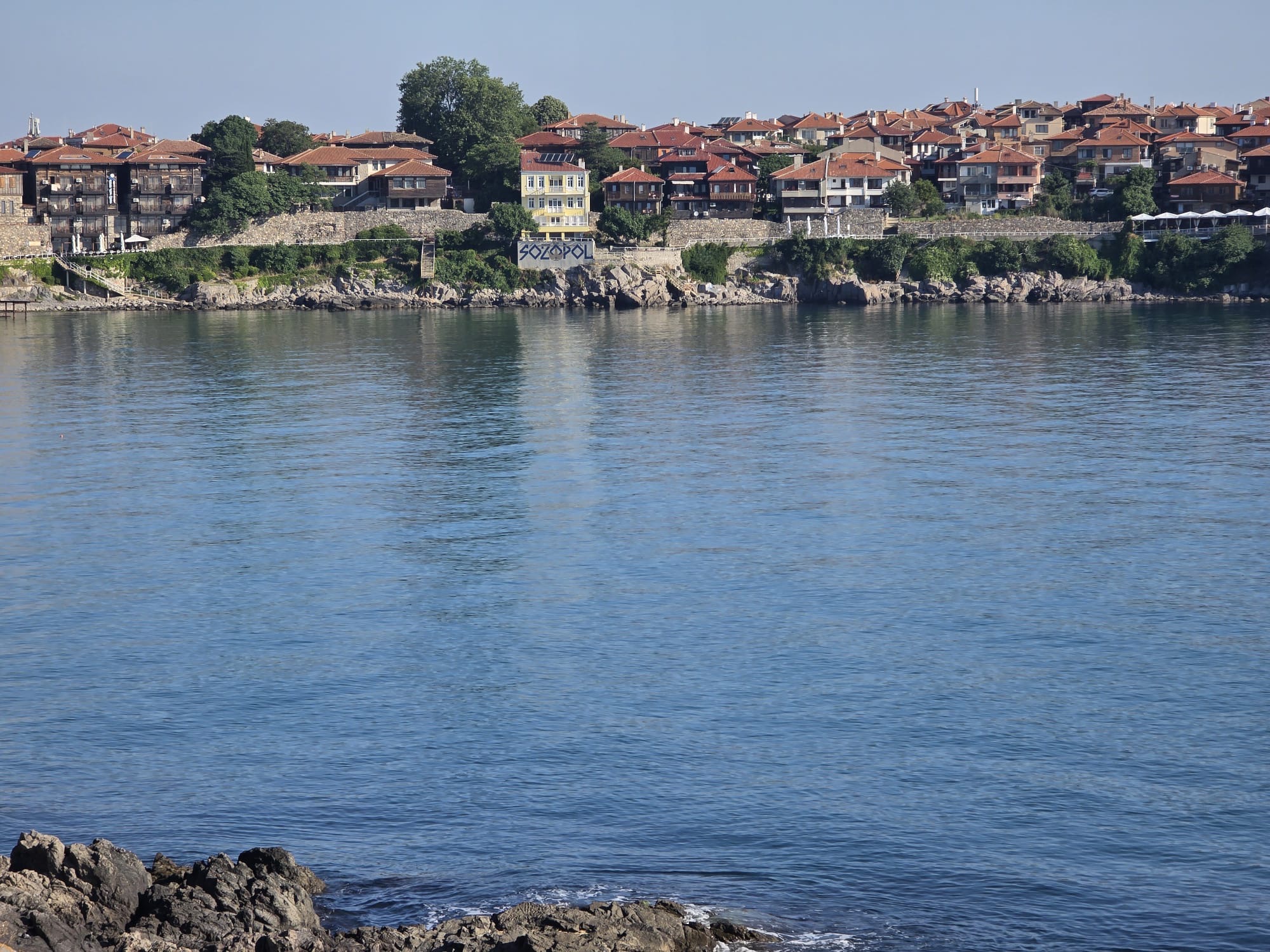 Панорама към стария Созопол с крайбрежни къщи, крепостна стена и море